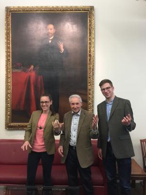 3 people standing in front of painting